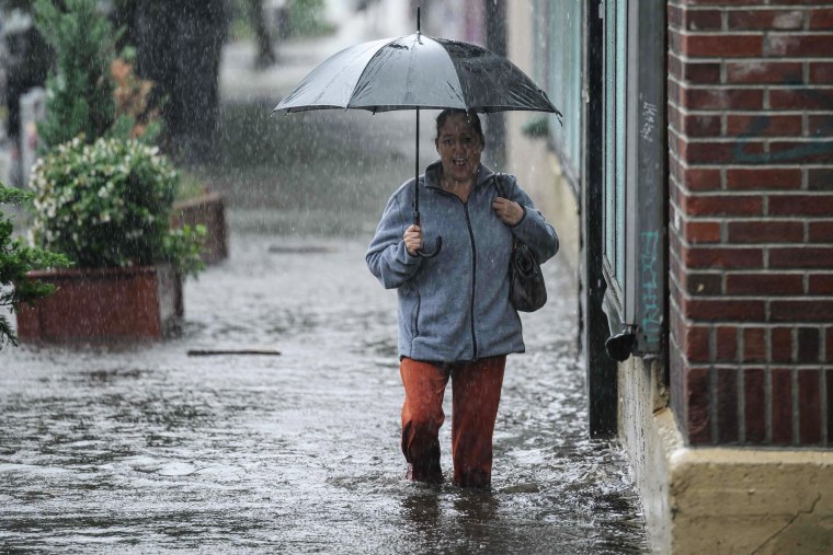 A woman walks through through floodwaters in Brooklyn, N.Y., on Sept. 29, 2023.
