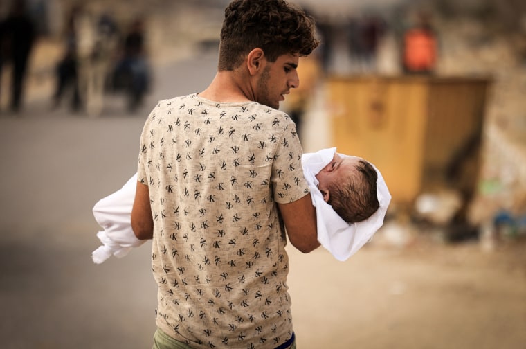 A child from the Al-Zanati family killed with other family members  is carried to a waiting vehicle to be driven for burial in Khan Yunis on Oct. 23, 2023, as battles continue between Israel and the Palestinian Hamas group.