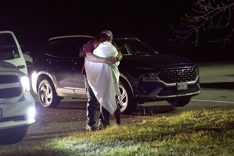 A woman is comforted at a reunification center at Auburn Middle School in Auburn, Maine, after shootings in Lewiston on Oct. 25, 2023.  