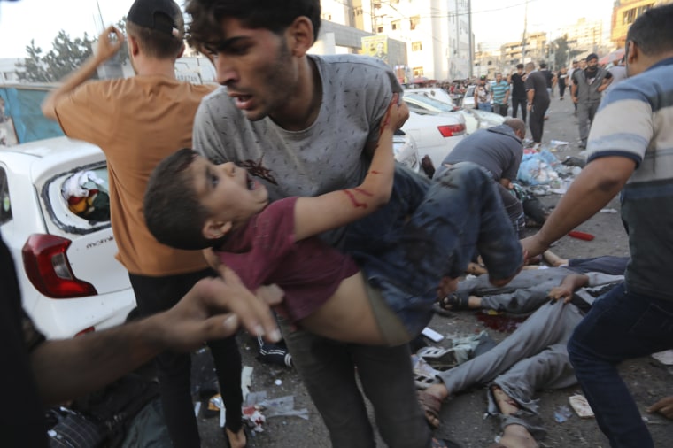 An injured Palestinian boy is carried following a strike outside of the al-Shifa hospital in Gaza City on Nov. 3, 2023.