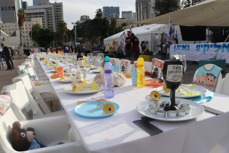 Children's toys and a bib have been left at an empty table set up in honor of those taken hostage Oct. 7.